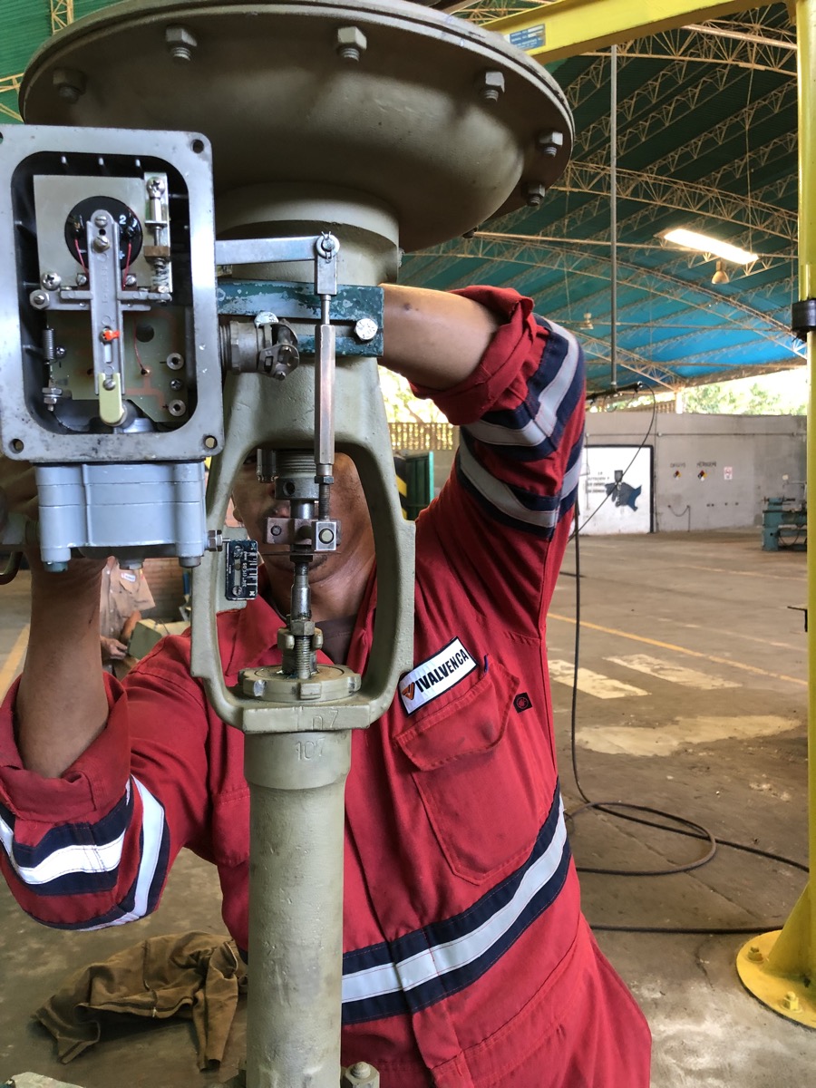 Técnico de IVALVENCA calibrando el posicionador de una válvula de control en el taller