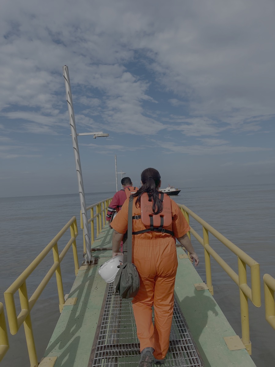 Personal de IVALVENCA cruzando el muelle de acceso a una plataforma en el Lago de Maracaibo