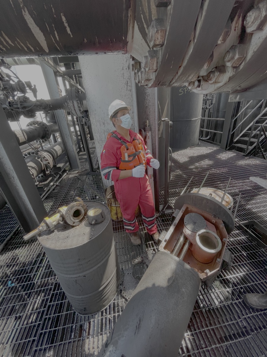 Técnico junto a una válvula de tapón desarmada para inspección en plataforma